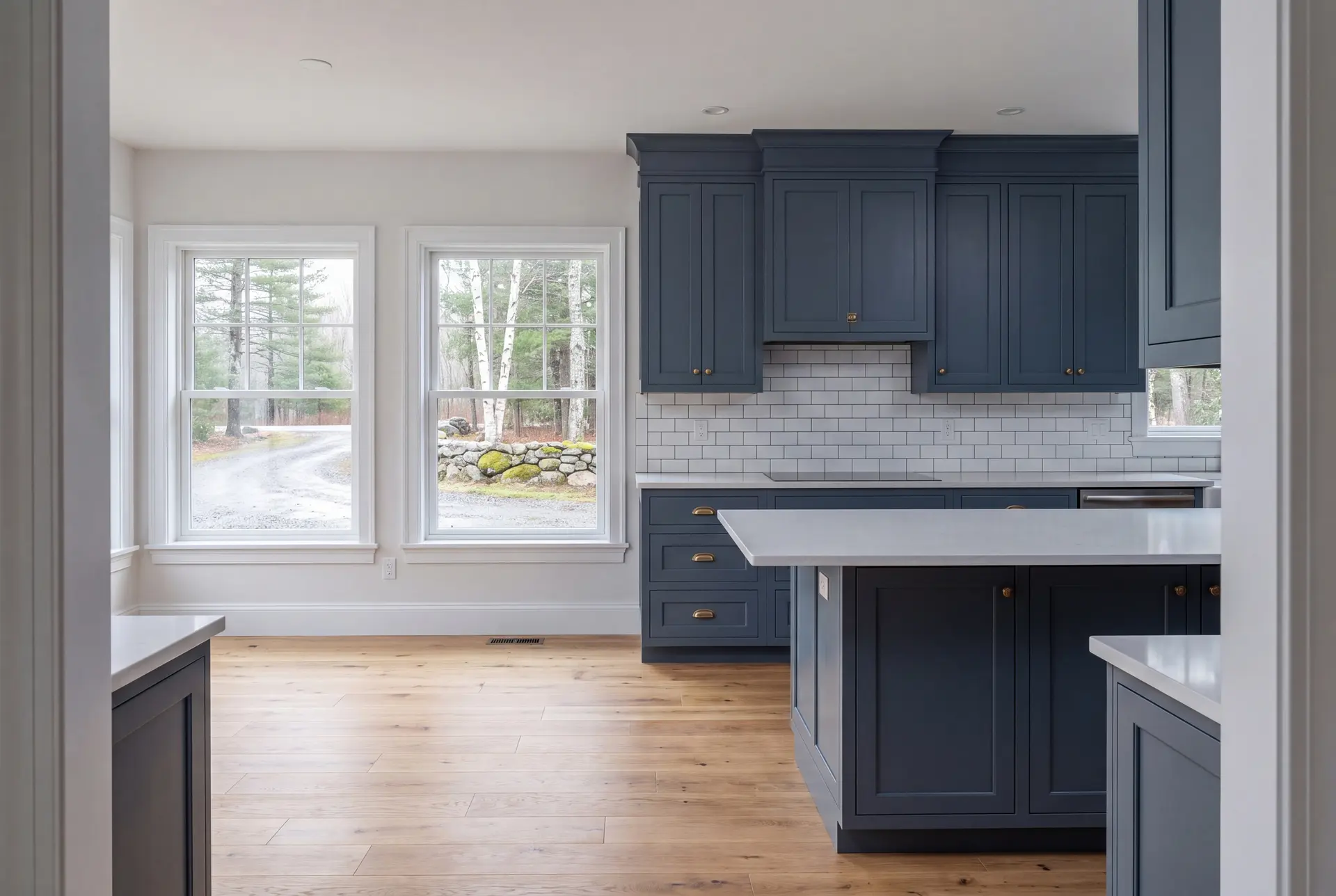 Illustration: A newly finished kitchen with blue cabinets, white countertops, and oak flooring, viewed from a doorway