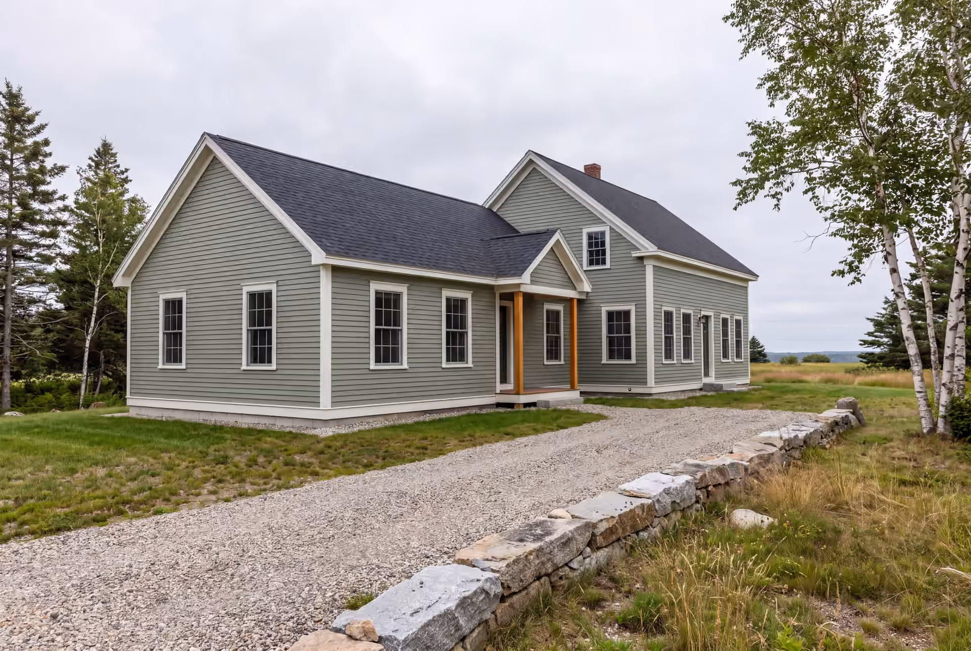 home addition builder in Buxton, ME: illustrative scene, A sage green farmhouse with a new addition, gravel driveway, and stone wall