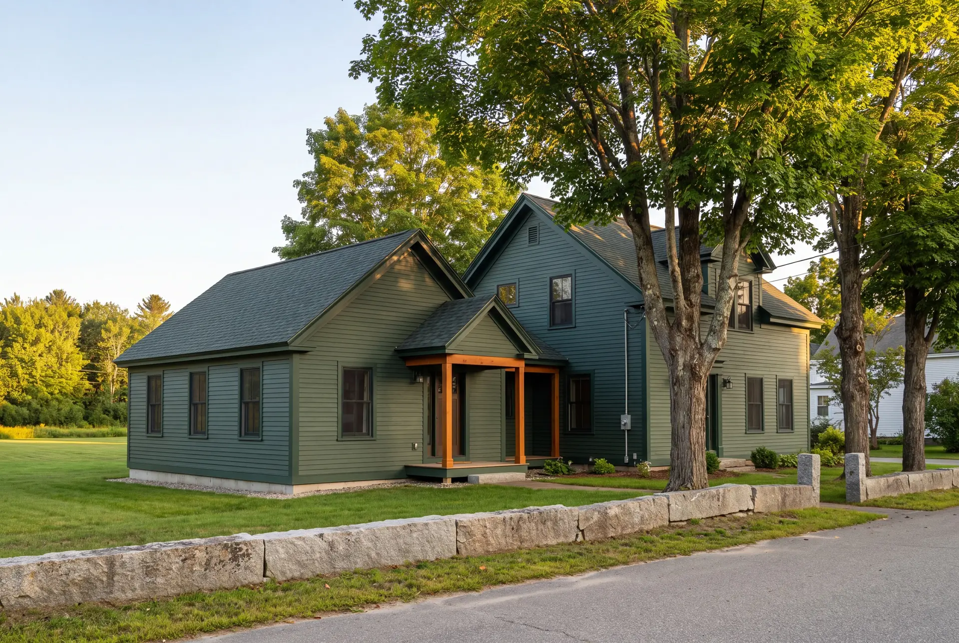 Illustration: A two-story house with a single-story addition, both painted green, viewed from the exterior with a stone wall and road in the foreground