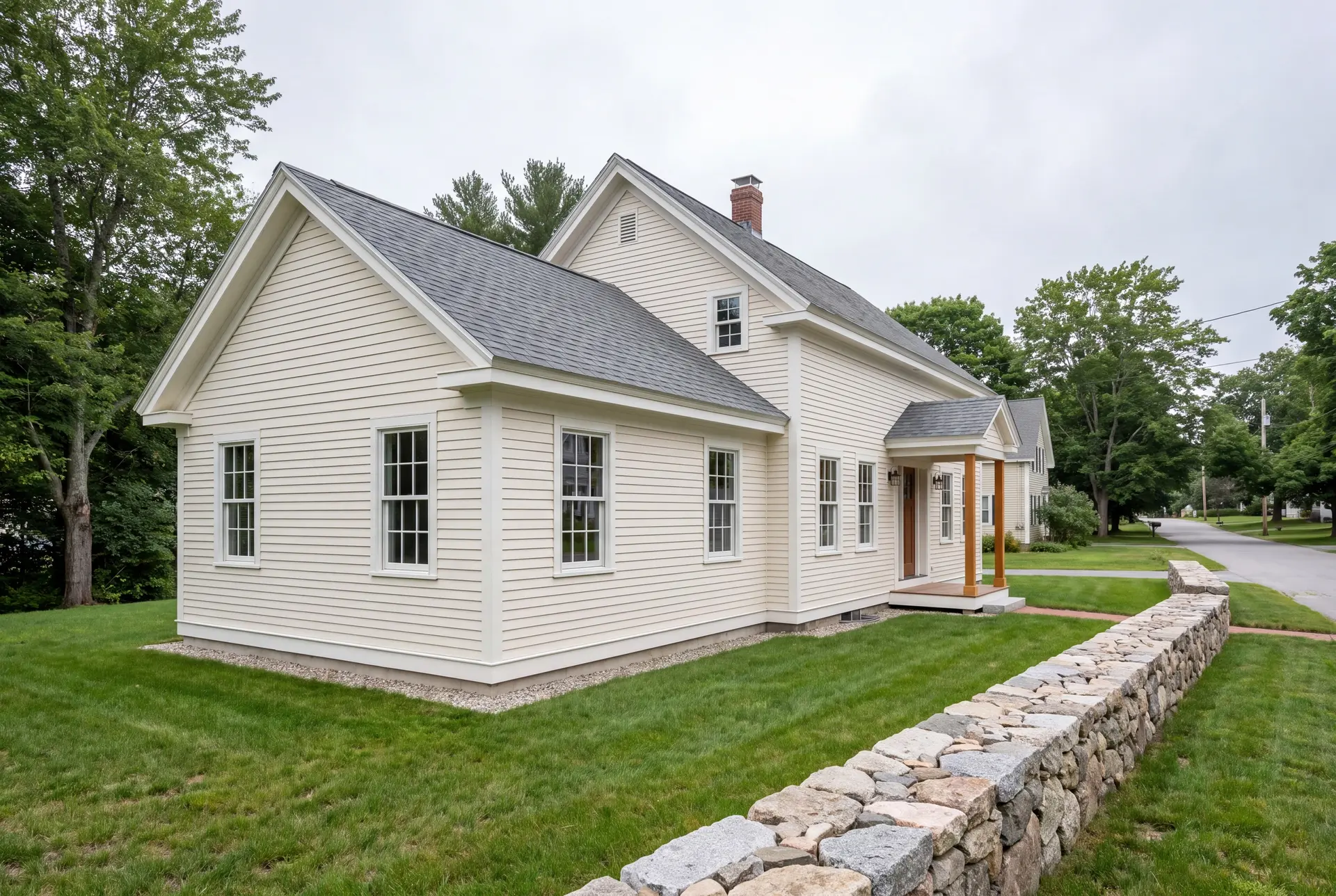 Illustration: A pale cream clapboard farmhouse with a new addition, gray roof, and white trim, seen from a three-quarter exterior view with a stone wall in the foreground