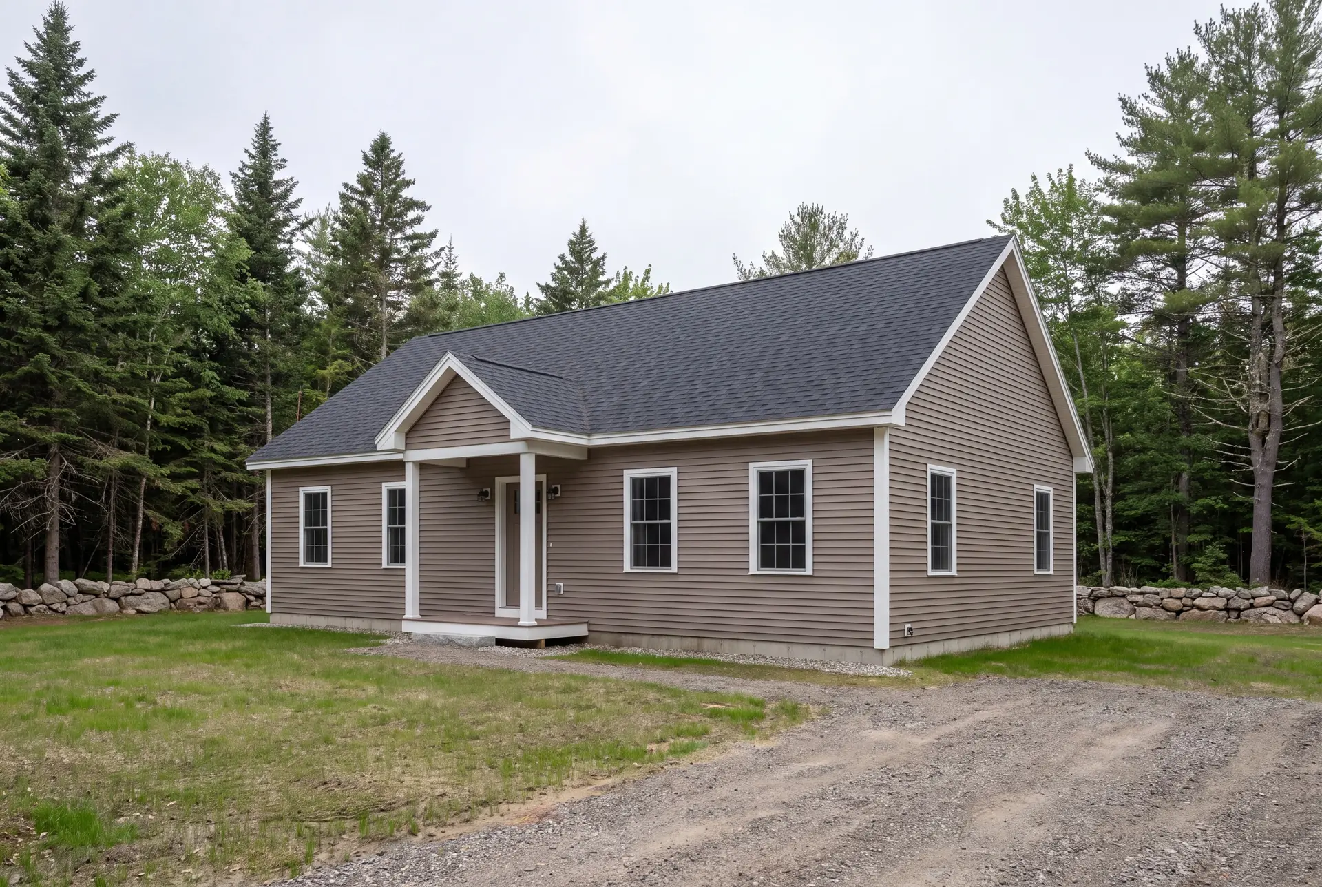 Illustration: A newly built one-story ranch house with taupe siding and a dark roof, surrounded by trees and a gravel driveway