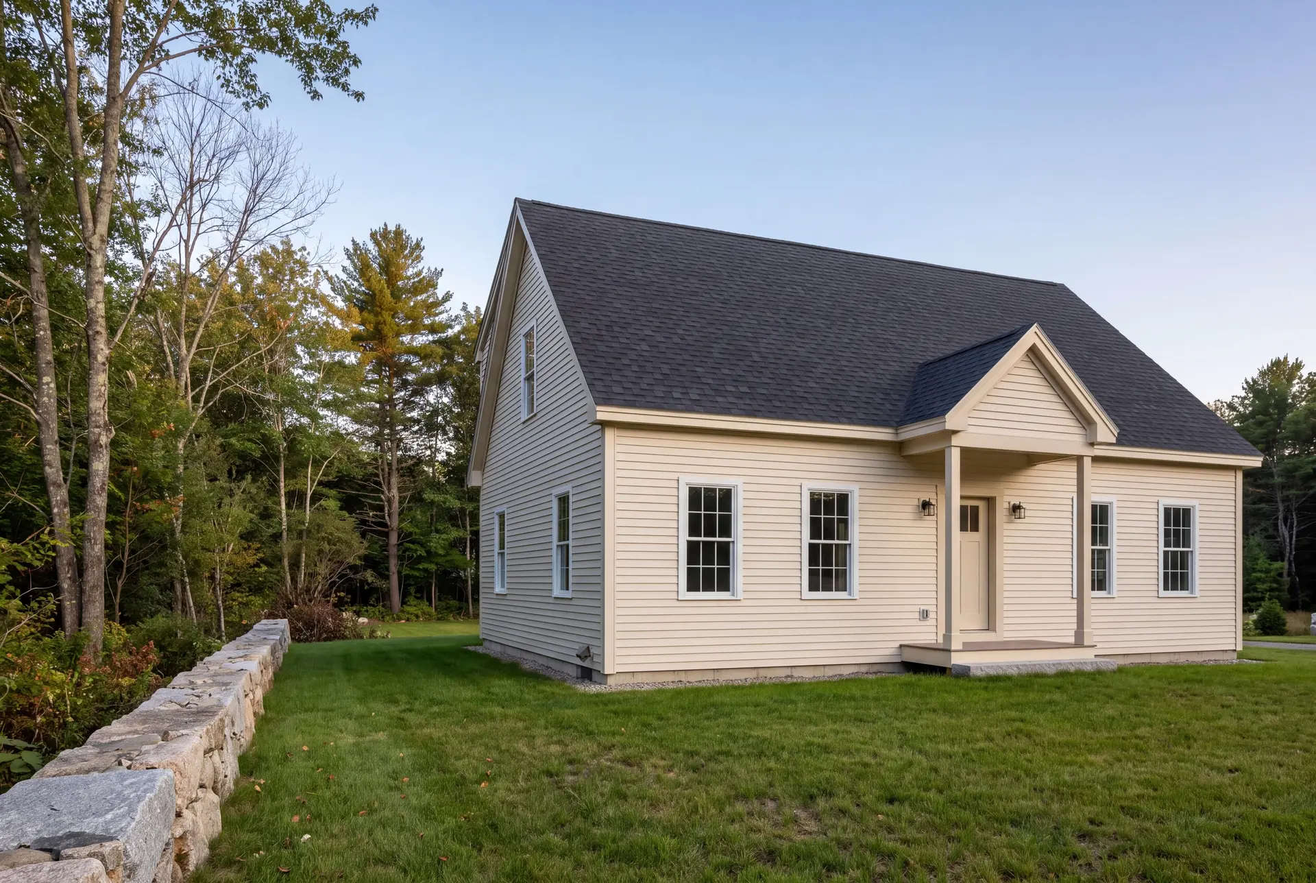 Illustration: A newly built cream-colored cottage with a dark gray roof and white-trimmed windows, set against a backdrop of trees and green grass