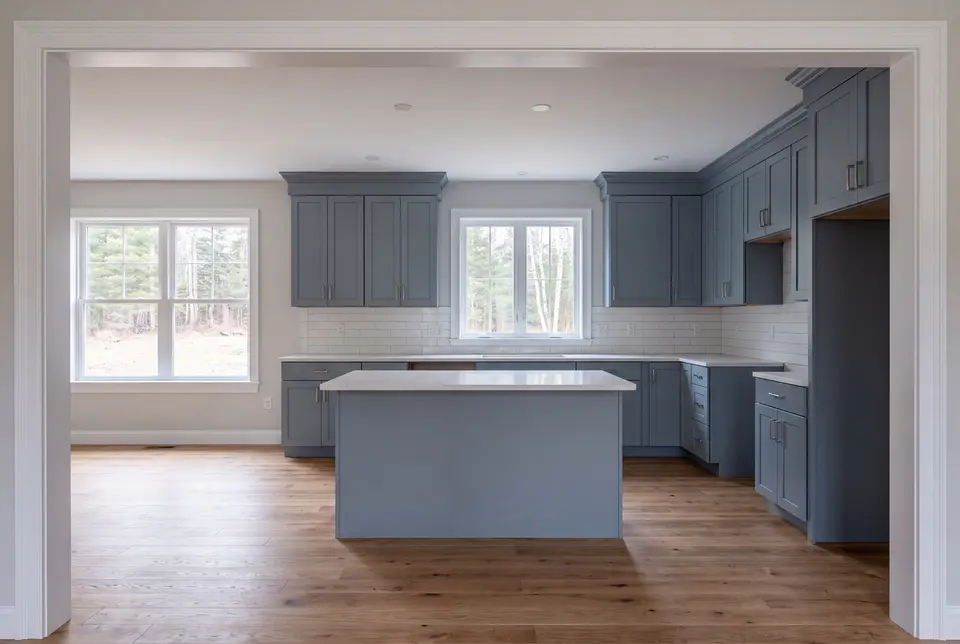 Illustration: A newly finished kitchen with blue-gray cabinets, a white quartz island, and oak floors, viewed from a doorway