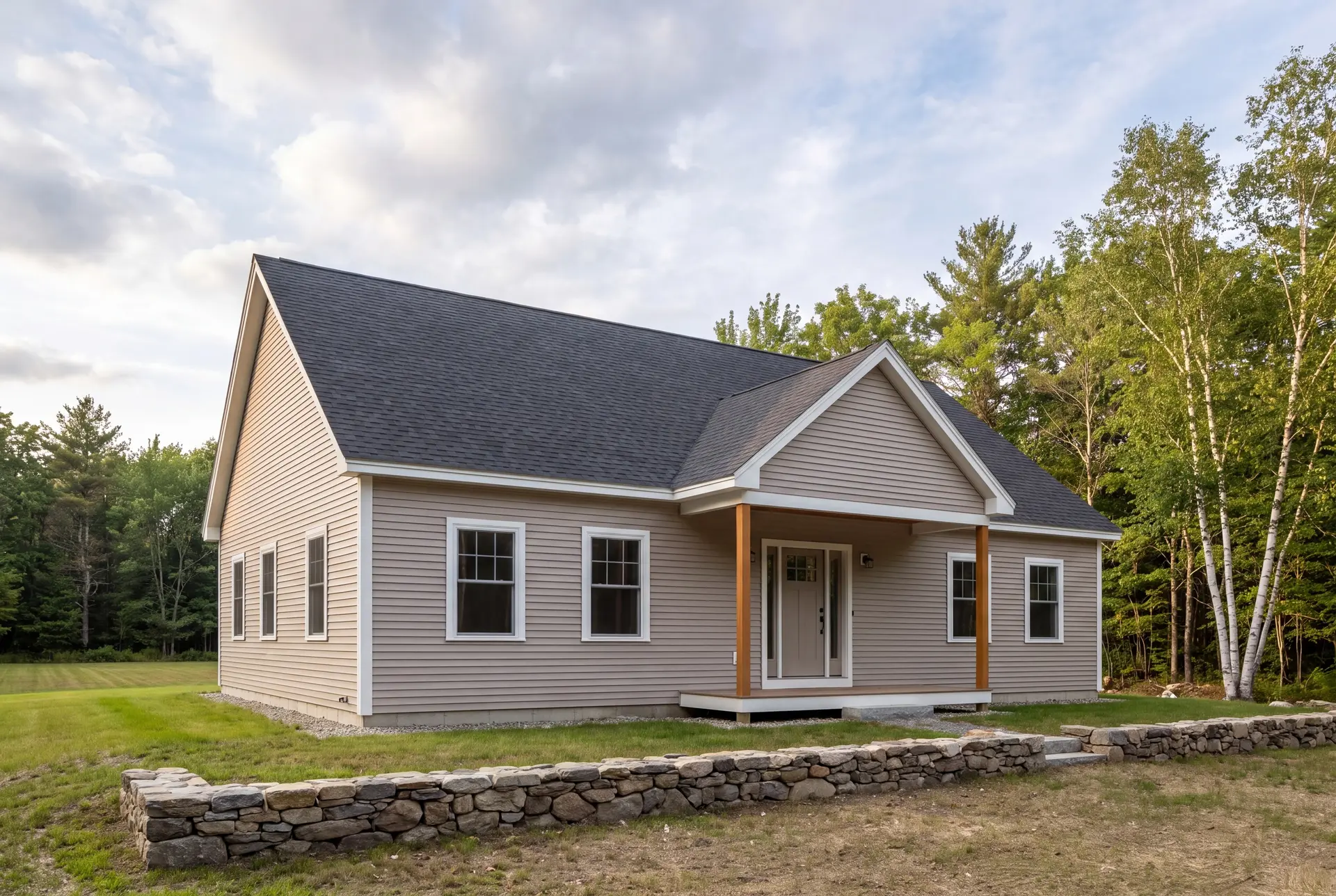 Illustration: A newly built single-story house with light brown siding, a dark gray roof, and a covered front porch, surrounded by grass and trees under a cloudy sky