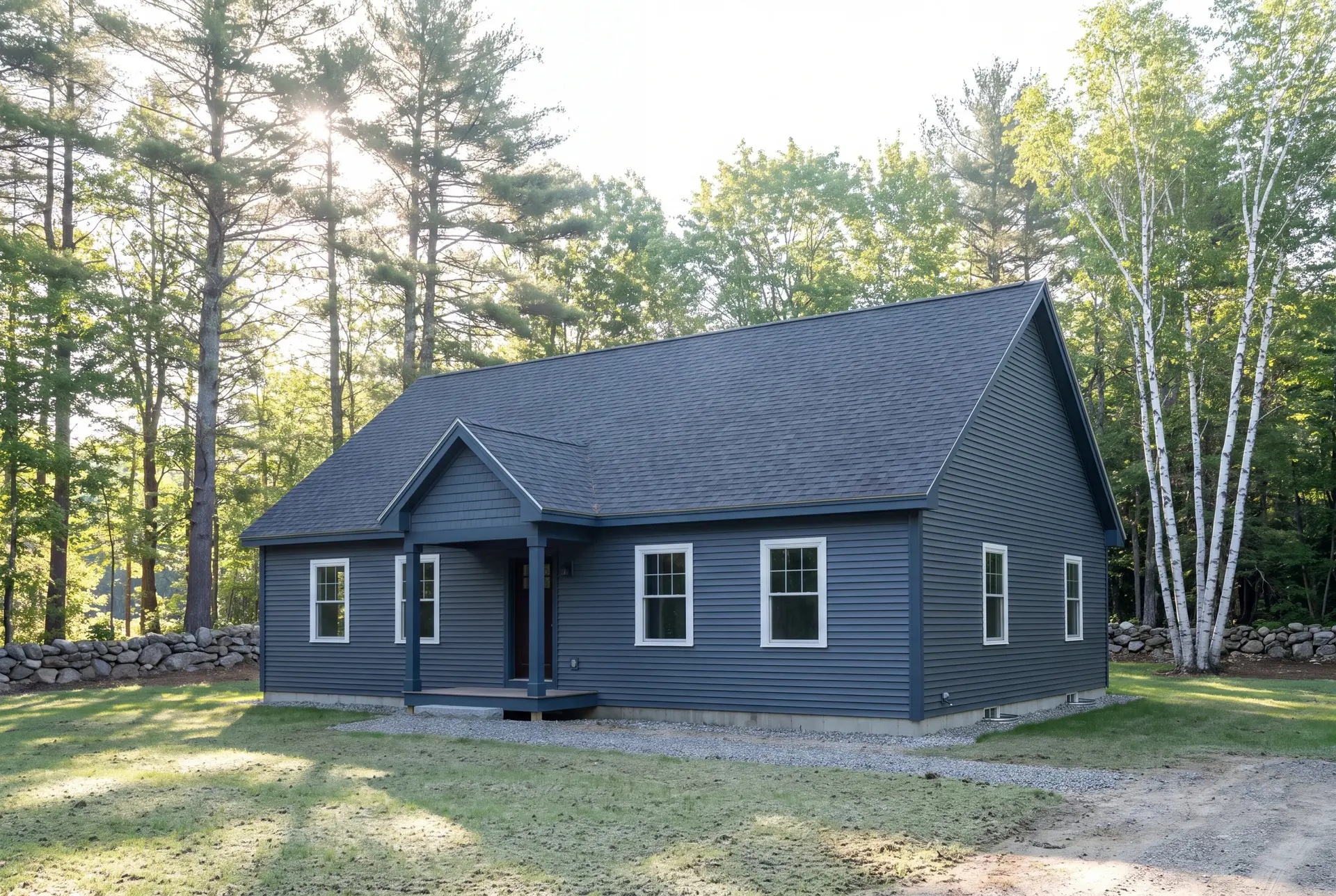 Illustration: A newly built, single-story ranch house with dark blue siding, a gray roof, and white-trimmed windows, surrounded by trees and a stone wall